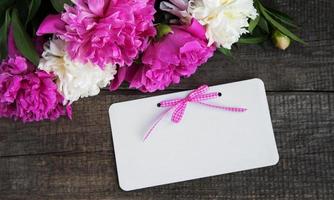 tarjeta de invitación y flores de peonía rosa foto