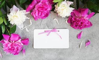 invitation card and pink peony flowers photo