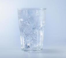 un vaso de agua transparente para bebidas frías. gotas de hielo y agua se adhieren al borde del vaso. agua de soda con cubitos de hielo foto