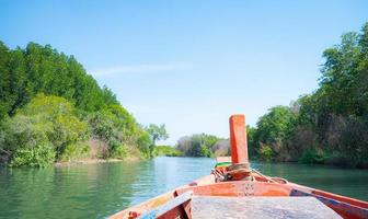 Part of a red motor boat that looks like a small fishing boat of the villagers. sailing on water to go out into the sea and mangrove forests photo