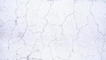 Cracks on the surface of the plaster wall or white plaster wall. Rough surfaces with cracks. photo