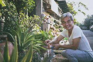 anciano asiático relajándose con cara sonriente en el jardín de su casa