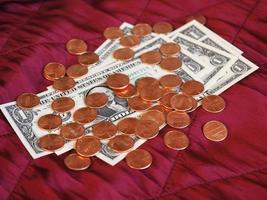 Dollar notes and coin, United States over red velvet background photo