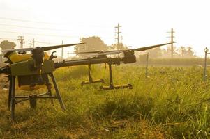 Agriculture drone flying and spraying fertilizer and pesticide over farmland,High technology innovations and smart farming photo