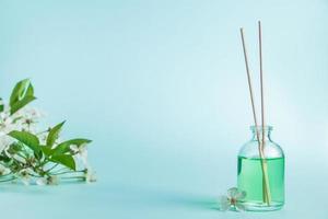 Aromatic diffuser and flowers on a blue background. photo