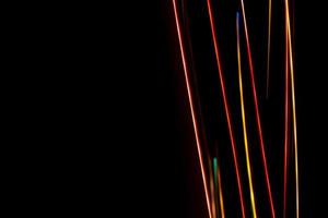 Bright multicolored diagonal lines rays on black. Abstract dark background banner. photo