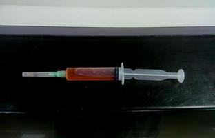 A syringe with Pleural fluid sample isolated, which is ready for biochemical test. closeup photo