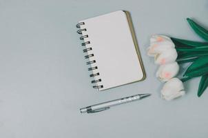 Top view flat lay notebook and flower and pen on table.Copy space