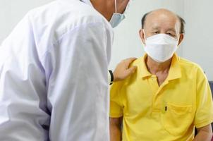 doctor is holding an elderly man's hand to cheer him up. photo