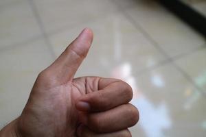 left hand of man with thumb up photo