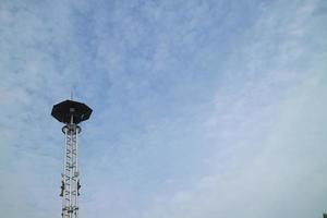 a high lamppost under a bright cloud photo