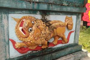 yellow lion carving on the wall photo