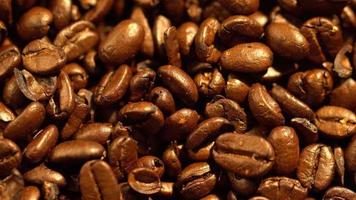 Macro shot of cup with hot coffee on roasted coffee beans in 4K video