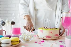 Beautiful woman celebrating birthday party cutting a cake photo