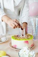 Woman in white party clothes preparing birthday table photo