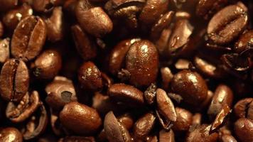 Macro shot of cup with hot coffee on roasted coffee beans in 4K video