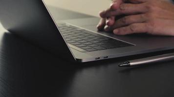 homme d'affaires travaillant avec un nouvel ordinateur portable moderne et des lunettes sur un bureau en bois au ralenti video
