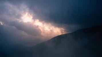 time-lapse van bergnatuur met mistige wolken snelle beweging. prachtig landschap in de ochtend tijdens zonsopgang met mist over de bergen. video