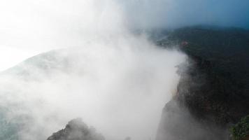 lapso de tempo da natureza da montanha com movimento rápido de nuvens enevoadas. bela paisagem de manhã durante o nascer do sol com neblina sobre as montanhas. video