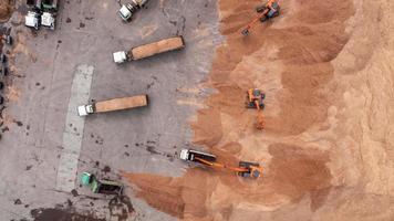 Une excavatrice tire une particule de bois de caoutchouc d'un camion dans un entrepôt d'exportation video