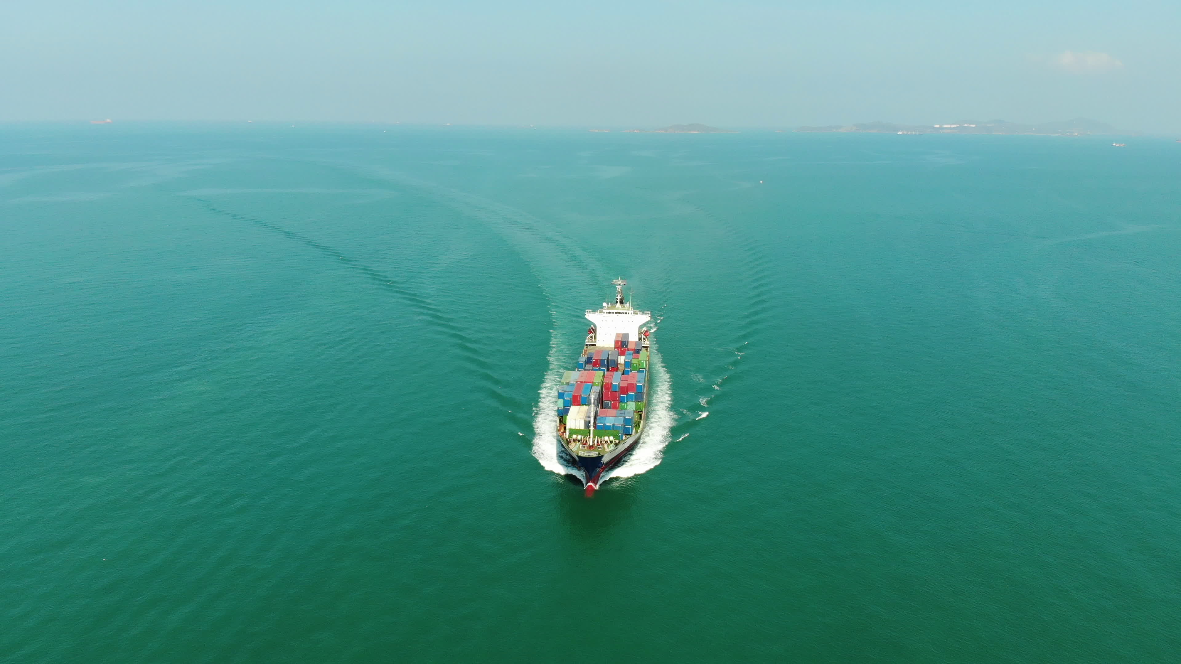 Aerial Top View Of Cargo Ship Carrying Container And Running For Export front-view-of-a-dynamic-image-of-cargo-ship-that-run-in-the-middle-of