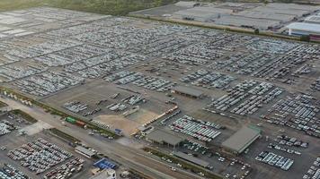 Aerial view a lot of new car for import and export shipping by ship , Smart dealership at car factory depot. video