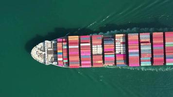 Aerial top view of cargo maritime ship with contrail in the ocean ship carrying container and running for export  concept technology freight shipping by ship smart service video