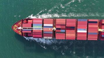 bovenaanzicht vanuit de lucht van vracht maritiem schip met contrail in de oceaan schip met container en rennen voor export concept technologie vracht verzending per schip slimme service video