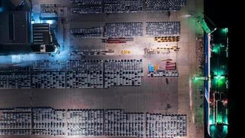 vista aerea timelapse un sacco di auto nuove che corrono verso la nave mercantile per l'importazione e l'esportazione di spedizione via nave, concessionaria intelligente al deposito di auto. video