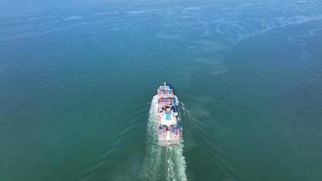 Aerial top view of cargo maritime ship with contrail in the ocean ship carrying container and running for export  concept technology freight shipping by ship smart service video