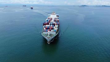 vista aerea dall'alto della nave da carico che trasporta container e funziona per l'esportazione di merci dal porto del cantiere merci al trasporto tecnologico personalizzato sull'oceano, sdoganamento. video