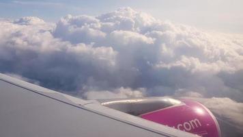 Flying over the clouds. View from plane aircraft passenger window with clouds and skyline horizon. photo