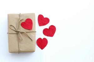 caja de regalo marrón y corazón de papel rojo sobre fondo blanco foto