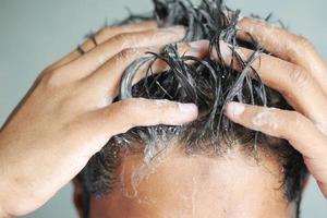 young men washes h his hair with shampoo . photo