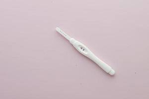 vista superior del kit de prueba de embarazo sobre fondo violeta claro foto