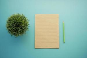 top view of blank paper and pencil on light green background photo