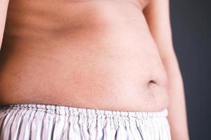 hombre gordo con una gran barriga contra el fondo amarillo foto