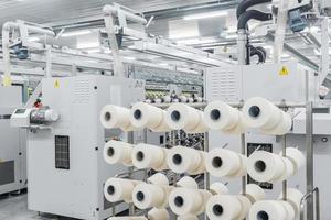 Maquinaria y equipo en el taller para la producción de hilo. interior de la fábrica textil industrial foto