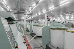 Machinery and equipment in the workshop for the production of thread. Interior of industrial textile factory photo