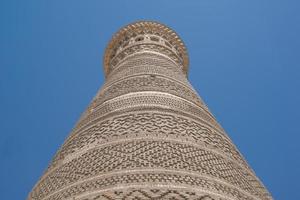 alta torre ovalada de ladrillos, antiguos edificios asiáticos. los detalles de la arquitectura de asia central medieval foto