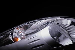 closeup of a car headlight on a black background. trimmed car headlight photo