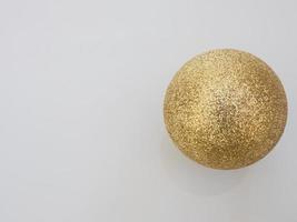 shiny Christmas ball gold color on a white background, top view photo