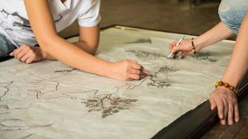 two girls painters draw a sketch through tracing paper, close-up photo