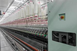 Maquinaria y equipo en el taller para la producción de hilo. fábrica textil industrial foto