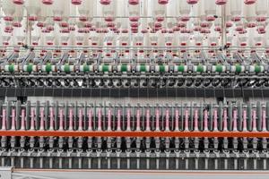 Maquinaria y equipo en el taller para la producción de hilo. fábrica textil industrial foto