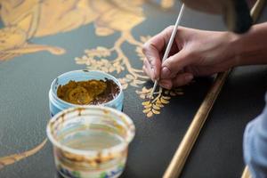 painter decorator draws a pattern of tree and leaves photo