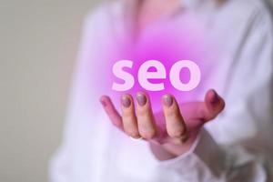 Seo in a woman's manicured hands, seo icon. photo