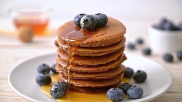 choklad pannkaka stack med blåbär och honung på tallrik video