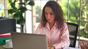 Latijnse vrouw die met de kaart van de hand aan de werkruimte thuis werkt video