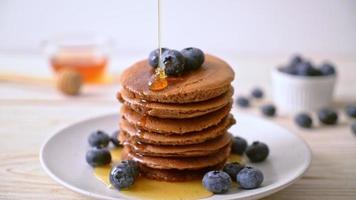 chocolate pancake stack with blueberry and honey on plate video